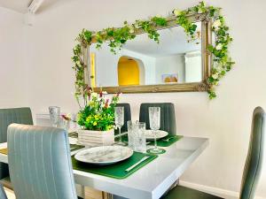 uma mesa de jantar com um espelho e cadeiras verdes em Winter Gardens Owners Suite Blackpool em Blackpool