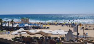 una spiaggia con molti ombrelloni e l'oceano di יחידת דיור a Rishon LeẔiyyon