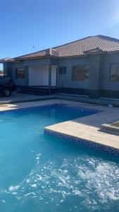 a swimming pool in front of a house at Carsi holiday Villa in Lusaka