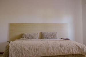 a bedroom with a large bed with a wooden headboard at Carsi holiday Villa in Lusaka