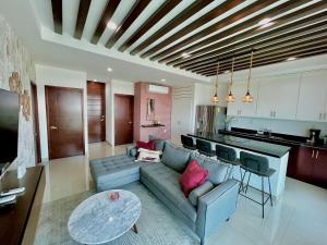 un soggiorno con un divano e un tavolo di The One D16 Sobre el Malecón Vista al Estadio de Baseball a Mazatlán