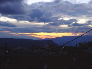um pôr-do-sol sobre uma cidade com montanhas ao fundo em Ariadne Guesthouse em Arachova