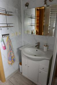 a white bathroom with a sink and a mirror at Kruszyniany 41 in Kruszyniany