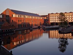 a city with buildings next to a body of water at Houseboat Hotels in Sheffield