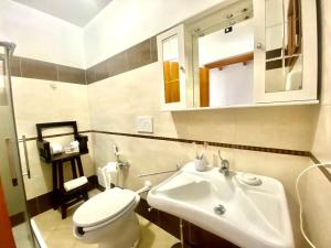 bagno con servizi igienici bianchi e lavandino di Villa Pedrosu a Casa Linari