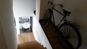 a bike hanging on a wall next to a staircase at Albergue Oasis in Sarria