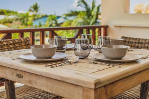 a wooden table with bowls and glasses on it at Puur Bonaire Boetiekhotel in Belnem