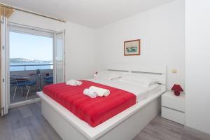 a white bedroom with a large bed with red blanket at Apartments Alajbeg in Trogir +96 photos