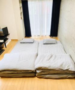 two twin beds in a room with a window at Marvelous Kokubunji - Vacation STAY 80468v in Kokubunji