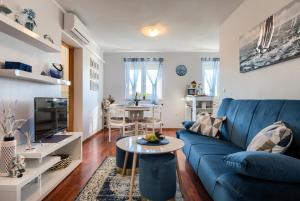 a living room with a blue couch and a table at Apartmani Plavi val in Vodnjan