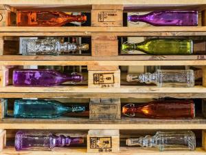 a display of wine bottles on a wooden shelf at Hotel Ibis Lisboa Sintra in Sintra