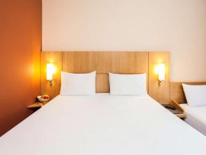 a large bed in a room with two white pillows at Hotel Ibis Lisboa Sintra in Sintra