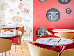 a restaurant with red walls and tables and chairs at Hotel Ibis Lisboa Sintra in Sintra