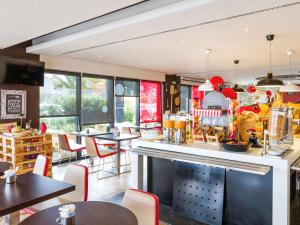 a restaurant with a bar with tables and chairs at Hotel Ibis Lisboa Sintra in Sintra