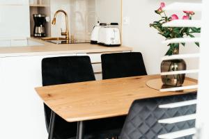 a kitchen with a wooden table and two black chairs at Studio Mrągowo in Mrągowo +11 photos