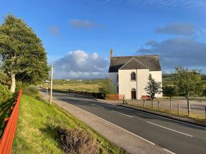 een kleine witte kerk aan de kant van een weg bij Sunnybank, Kensaleyre in Portree