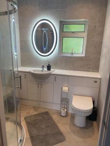 ein Badezimmer mit einem WC, einem Waschbecken und einem Spiegel in der Unterkunft Sunnybank, Kensaleyre in Portree