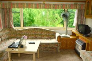 a living room with a couch and a window at Klarysewo bliżej Słońca in Mrągowo