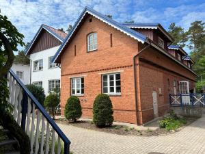 a red brick house with a metal roof at Banga & Sunrise Nida in Nida +21 photos