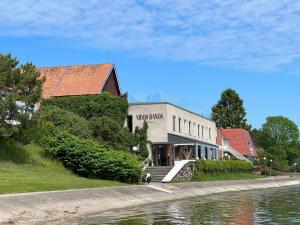 a building next to a body of water next to a building at Banga & Sunrise Nida in Nida