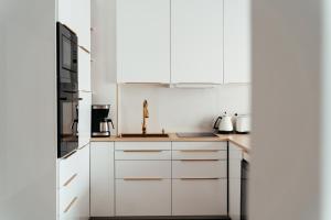 a kitchen with white cabinets and a sink at Studio Mrągowo in Mrągowo