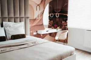a bedroom with a bed and a table and a desk at Studio Mrągowo in Mrągowo