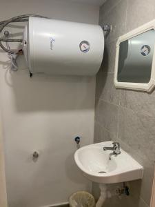 La salle de bains est pourvue d'un lavabo et d'un distributeur de serviettes en papier. dans l'établissement Pensión LF No Fumadores - Sin Ascensor, à Saragosse