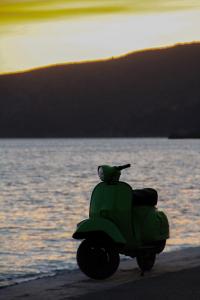 a green scooter parked on the beach near the water at Palataki in Kardamyli