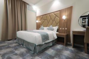 a hotel room with a large bed and a mirror at شقق كلاس للشقق المخدومة اقتصادي in Hail