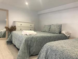 sypialnia z dwoma łóżkami i ręcznikami na nich w obiekcie Apartamento López w mieście Vejer de la Frontera
