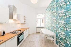 a kitchen with white cabinets and a blue and white wallpaper at Mariacki Church 3-ROOMS p4you pl in Krakow