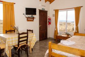 Pokój ze stołem, łóżkiem i oknem w obiekcie Cielos Patagónicos Aparts w mieście El Calafate