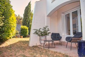 2 sedie e un tavolo su un patio di Agréable maison 3 chambres avec piscine a Carcassonne