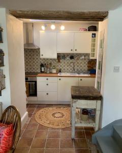 a kitchen with white cabinets and a table at Charming townhouse in Bruton in Bruton