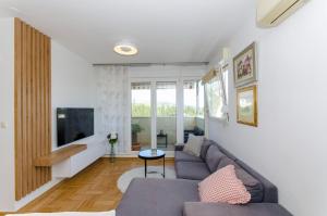 uma sala de estar com um sofá e uma televisão em Spacious and luxury apartment with sea view and secure garage em Split