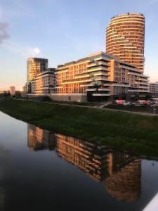 duży budynek z odbiciem w wodzie w obiekcie Capital Towers "FIRST CLASS" w mieście Rzeszów