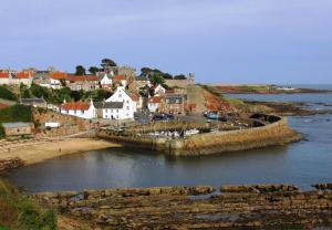 a town with a bridge over a body of water at Stoney Creek Cottage in Crail