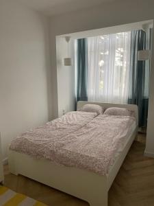 - un lit blanc dans une chambre avec fenêtre dans l'établissement Przytulny apartament, 200m od morza, Gdynia Orłowo, à Gdynia