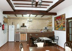 a kitchen and dining room with a table and a refrigerator at Casa Rural Hinojosa Del Duque in Hinojosa del Duque
