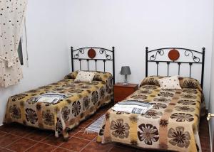 two beds sitting next to each other in a room at Casa Rural Hinojosa Del Duque in Hinojosa del Duque