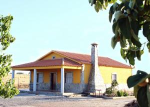 a small yellow house with a red roof at Casa Rural Hinojosa Del Duque in Hinojosa del Duque