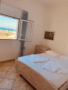 een slaapkamer met een bed en een groot raam bij A View Home _ Agkistri in Megalochori