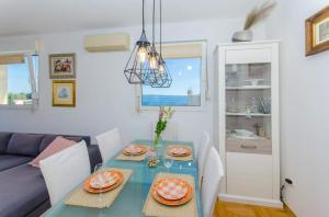 uma sala de jantar com uma mesa azul e um sofá em Spacious and luxury apartment with sea view and secure garage em Split