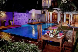 een zwembad in een huis met een tafel en stoelen bij Sandul Villa in Beruwala