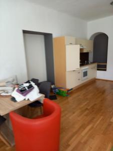 a living room with a table and a red chair at Ferienwohnung Murtal in Sankt Lorenzen bei Knittelfeld