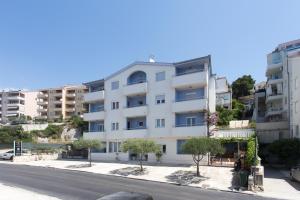 a white building on the side of a street at Apartments Alajbeg in Trogir