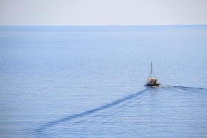 a small boat in the middle of the water at Palataki in Kardamyli