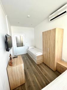 a bedroom with a bed and a small cabinet at E-home Apartments in Varna City