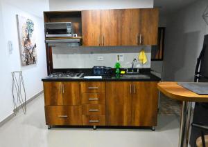 a kitchen with wooden cabinets and a sink at Andaliving Niquia Apartaestudio in Bello