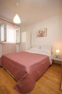 sypialnia z dużym łóżkiem i czerwonym kocem w obiekcie Apartments Nina w mieście Cavtat